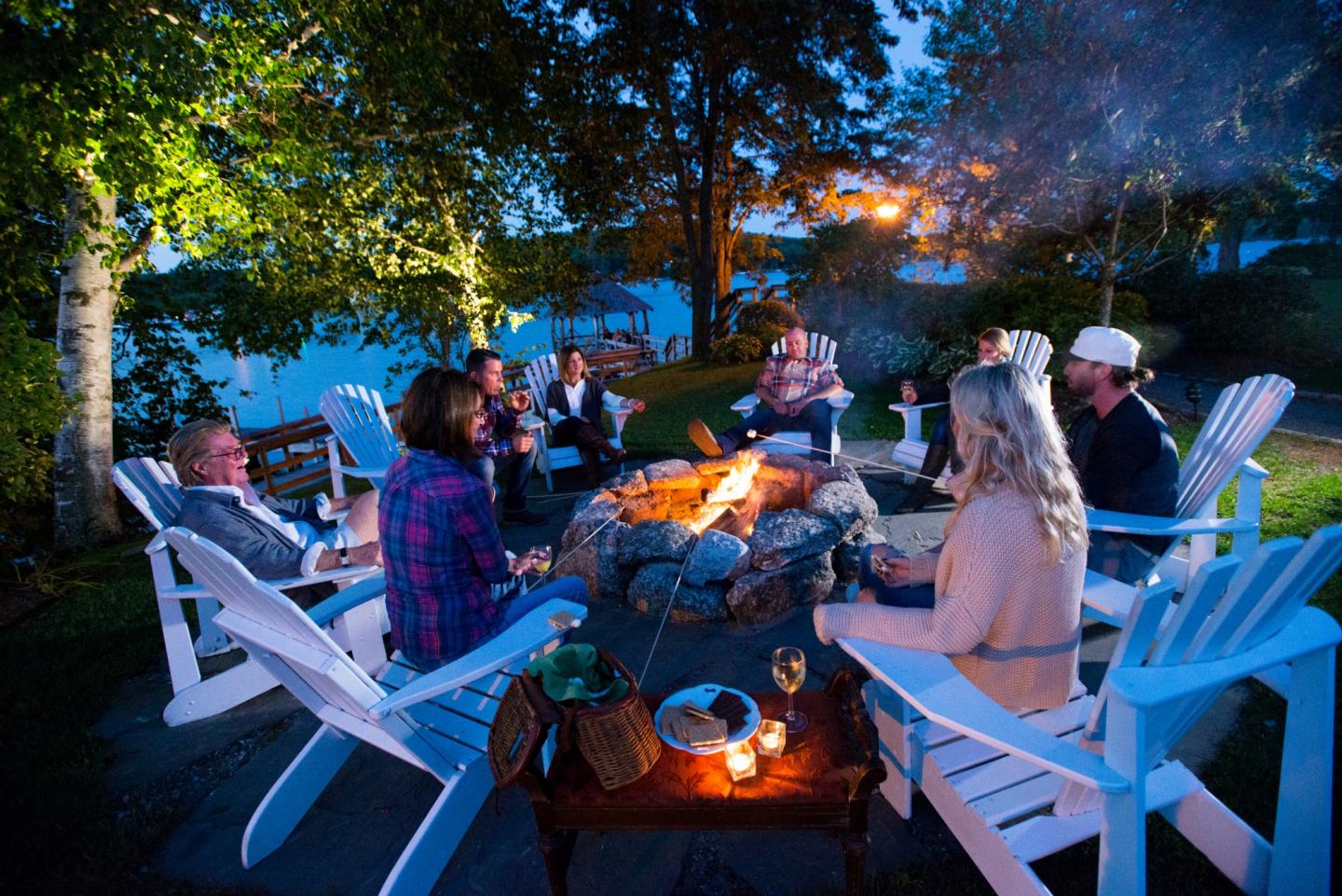 Guest gathered around a bonfire with s'mores