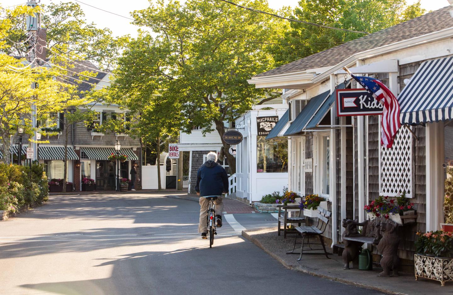 A man riding a bike through the streets of Edgartown, MA