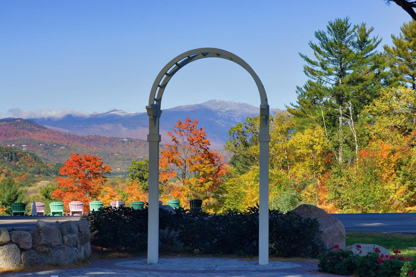 Wedding arch on stone patio with fall foliage and mountains in the background