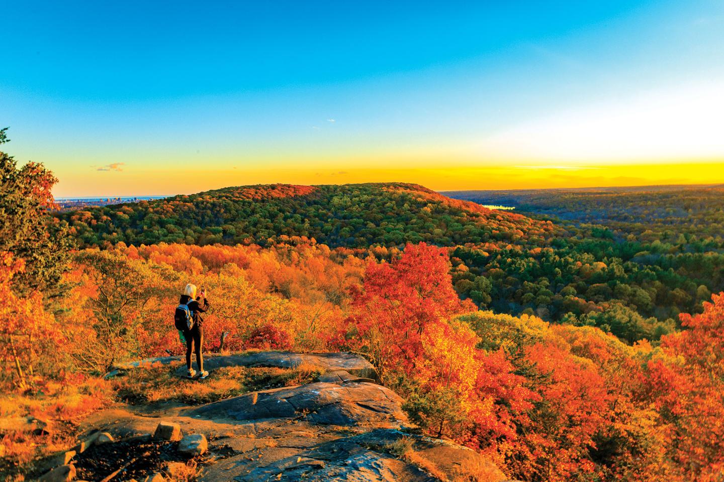 Scenic view of fall foliage in the mountains with a solo hiker