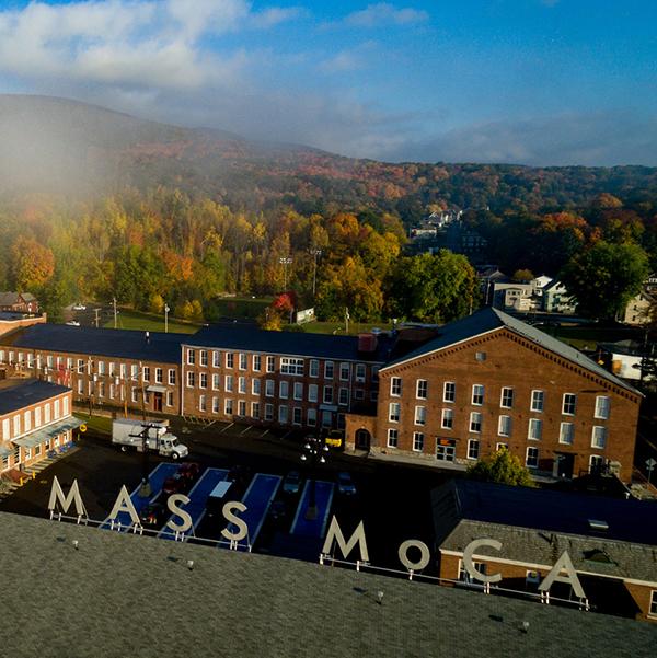 View of Mass MoCA building with fall foliage in the background