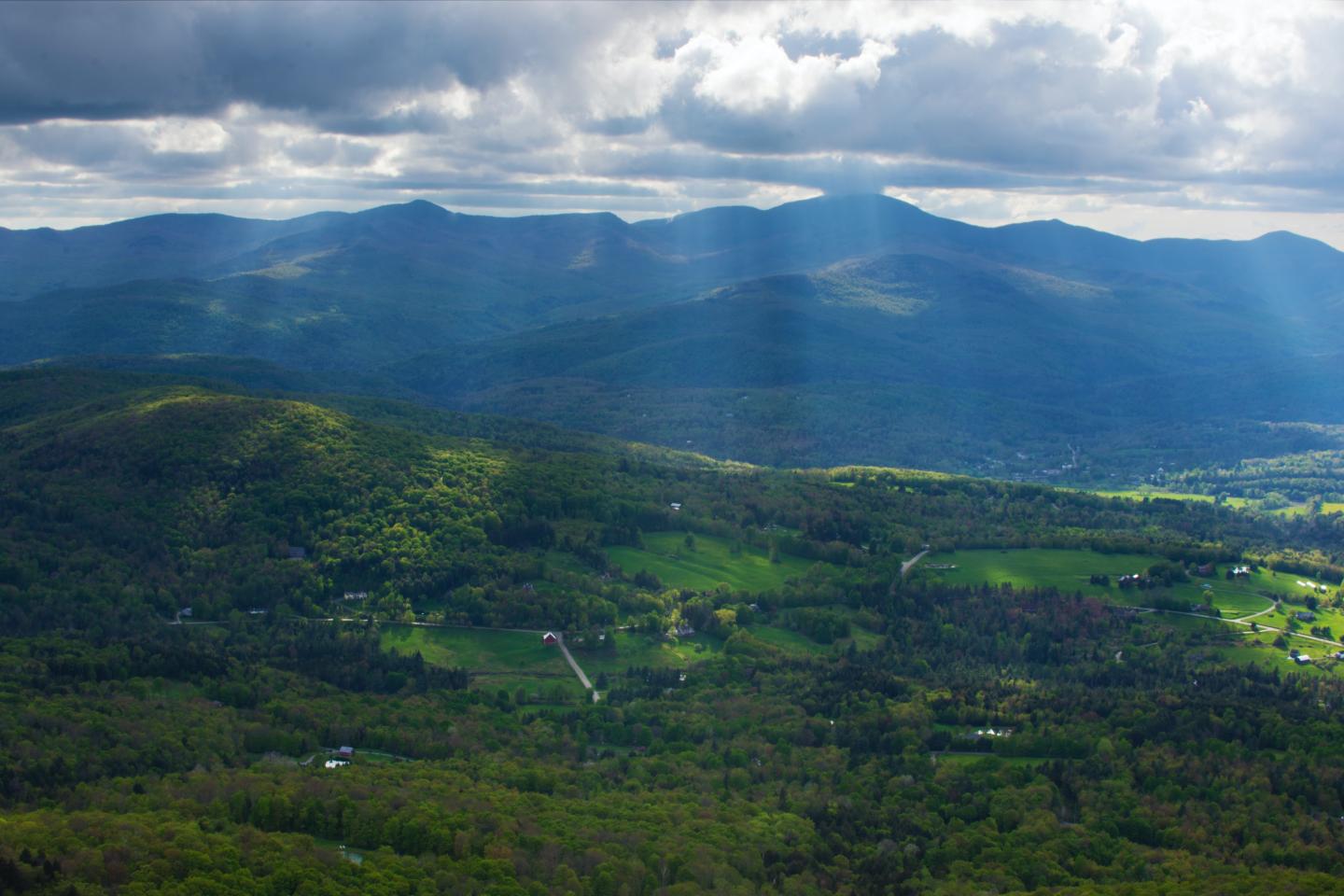 View of mountains with sunshine breaking through the clouds