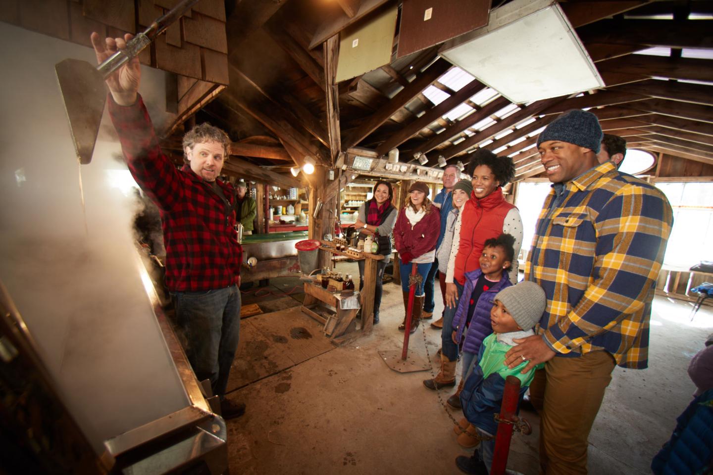 People inside a sugar house viewing the maple sugaring process