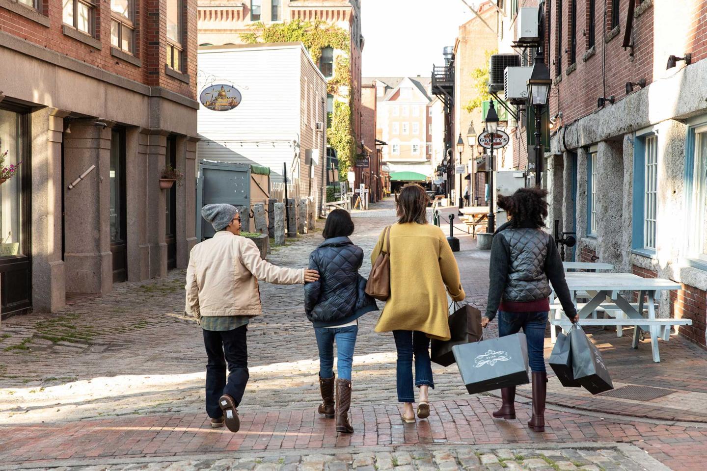 Group of people walking down the cobbled streets of Portland Maine