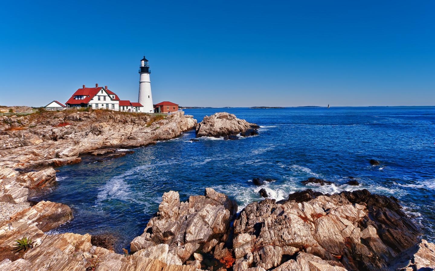 Rocky coastline with a white lighthouse in the background