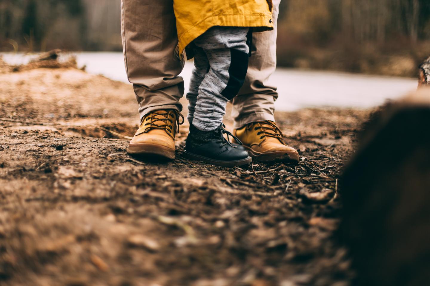 Closeup of kids hiking boots next to adult hiking boots