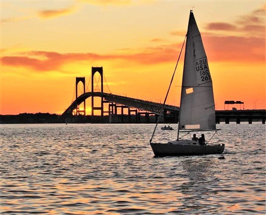 Boats sailing on the water with a bridge in the background