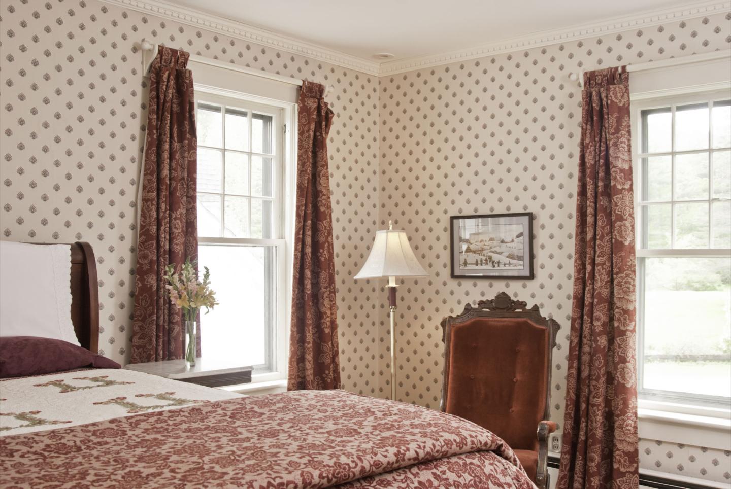 George's Room, complete with tasteful period wallpaper and shades of burgundy that make this room a frequent favorite of many guests.