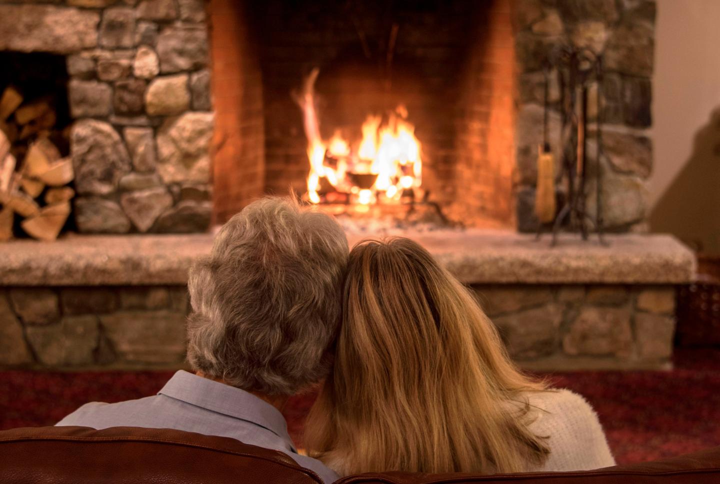 Couple snuggling by the fire in the Great Room