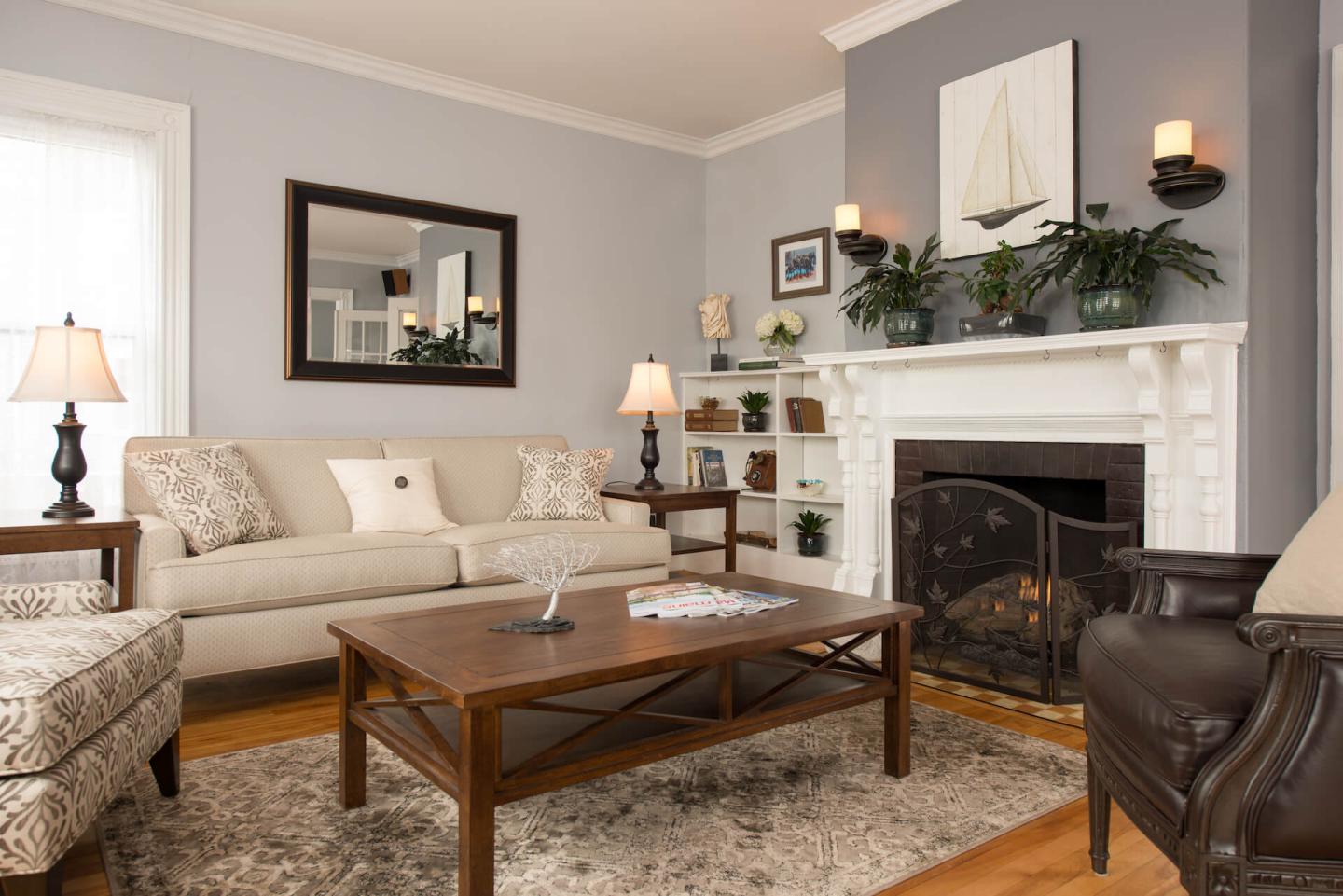 Living room with light blue walls, a leather chair, an upholstered chair, couch and a coffee table.