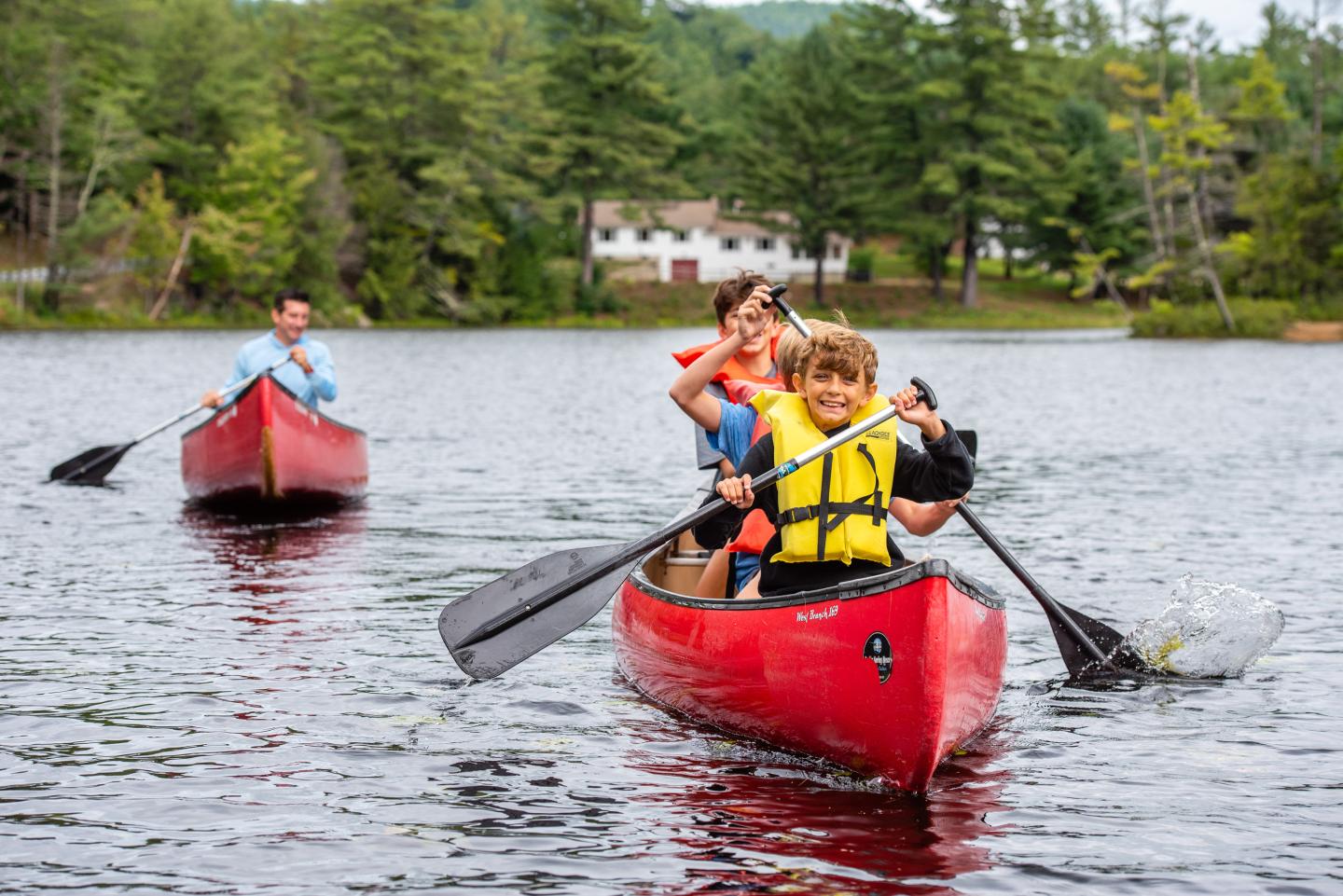 A family paddling canoes at Purity Spring Resort