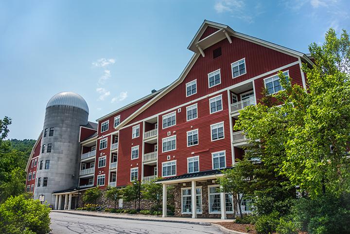 Exterior Clay Brook Hotel surrounded by trees on a sunny day