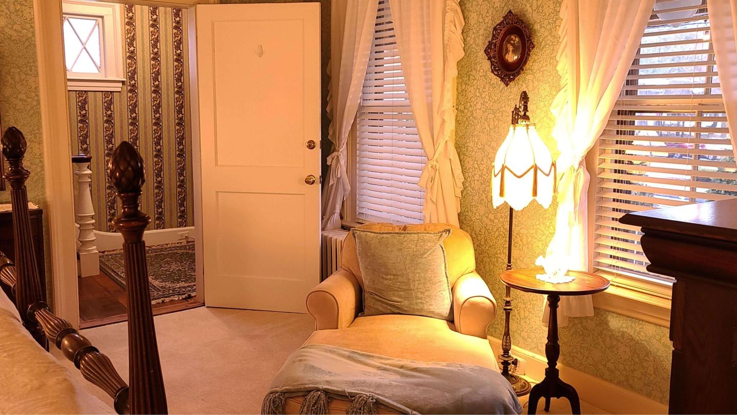 A plush chaise lounge sits in a comfortable guestroom.