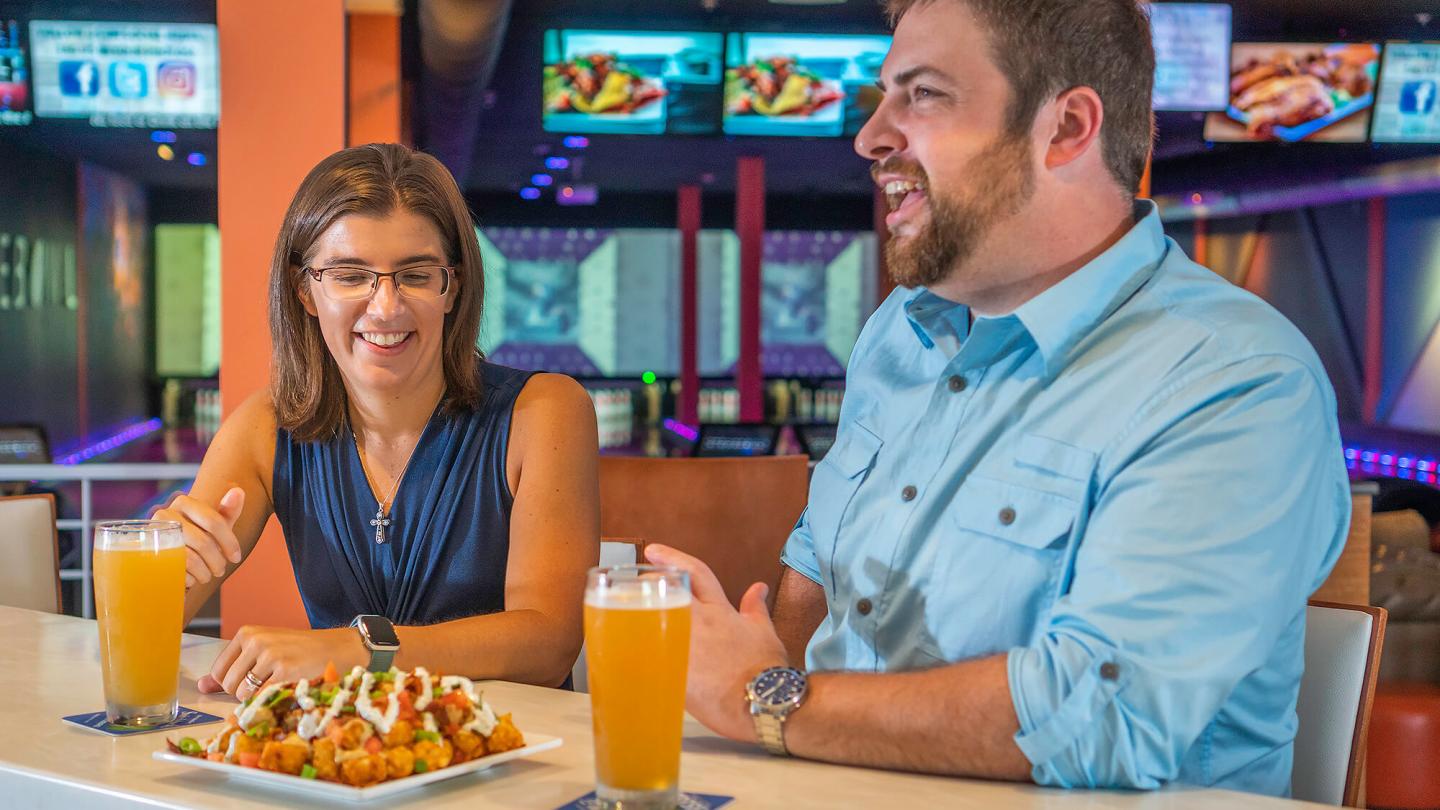 Couple eating and drinking at the bar at Stowe Bowl
