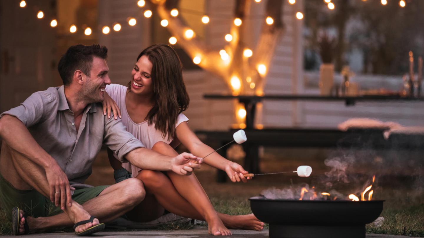 Romantic couple roasting marshmallows over an open fire