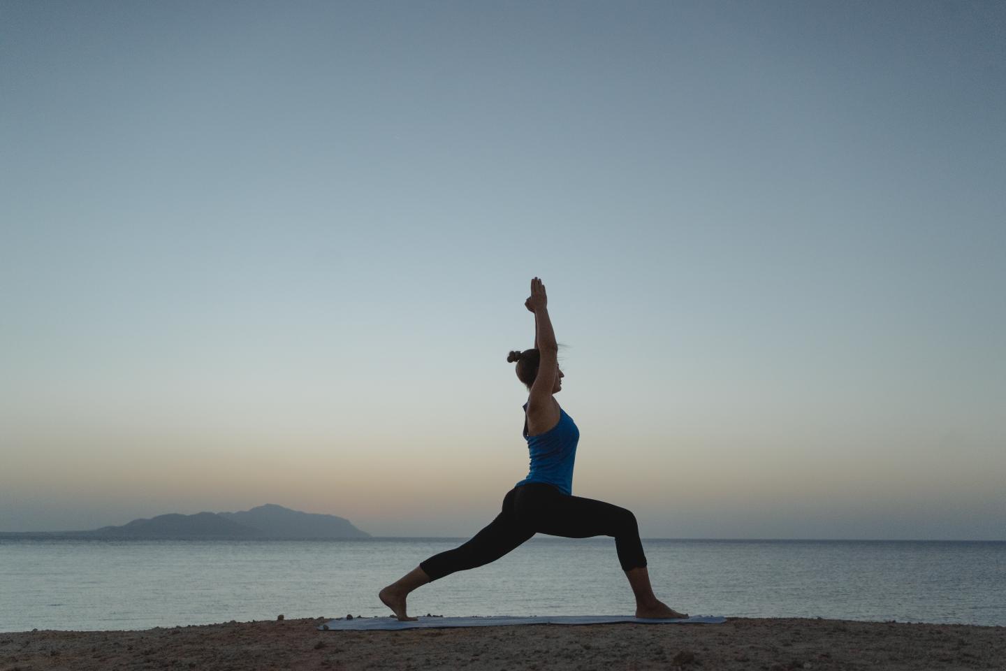 person doing yoga on the beach
