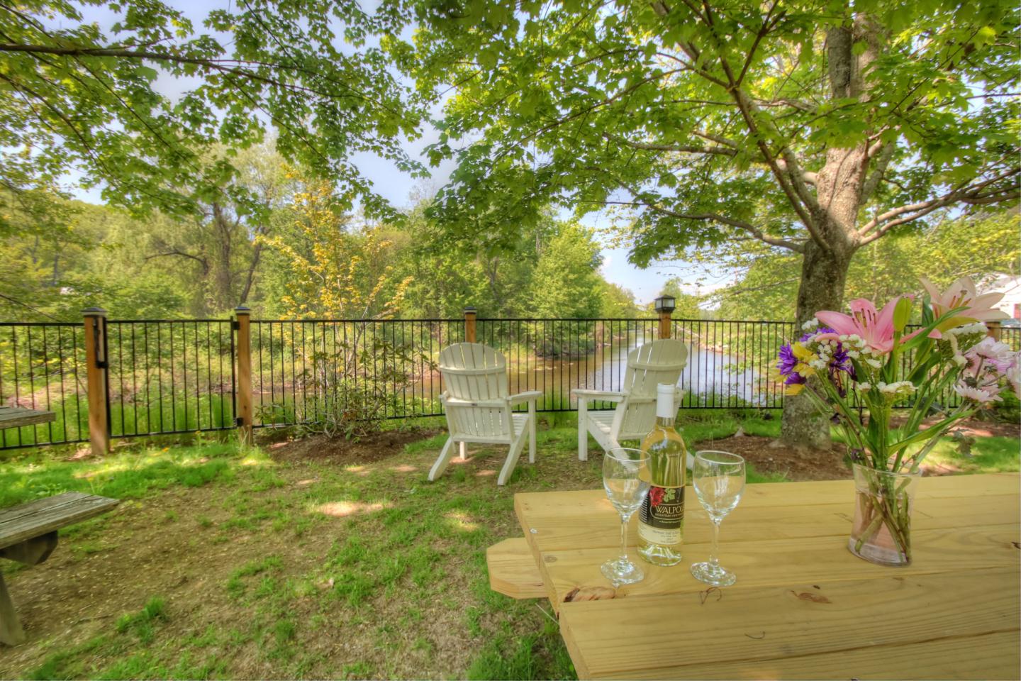Picnic table with wine glass overlooking a river